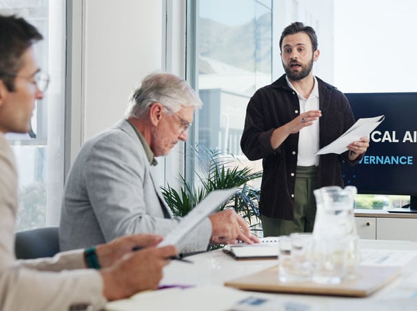 IT-ledelse diskuterer NSM-grunnprinsipper i et formelt møte, med fokus på styring, kontroll og risikohåndtering i henhold til norske krav til informasjonssikkerhet.