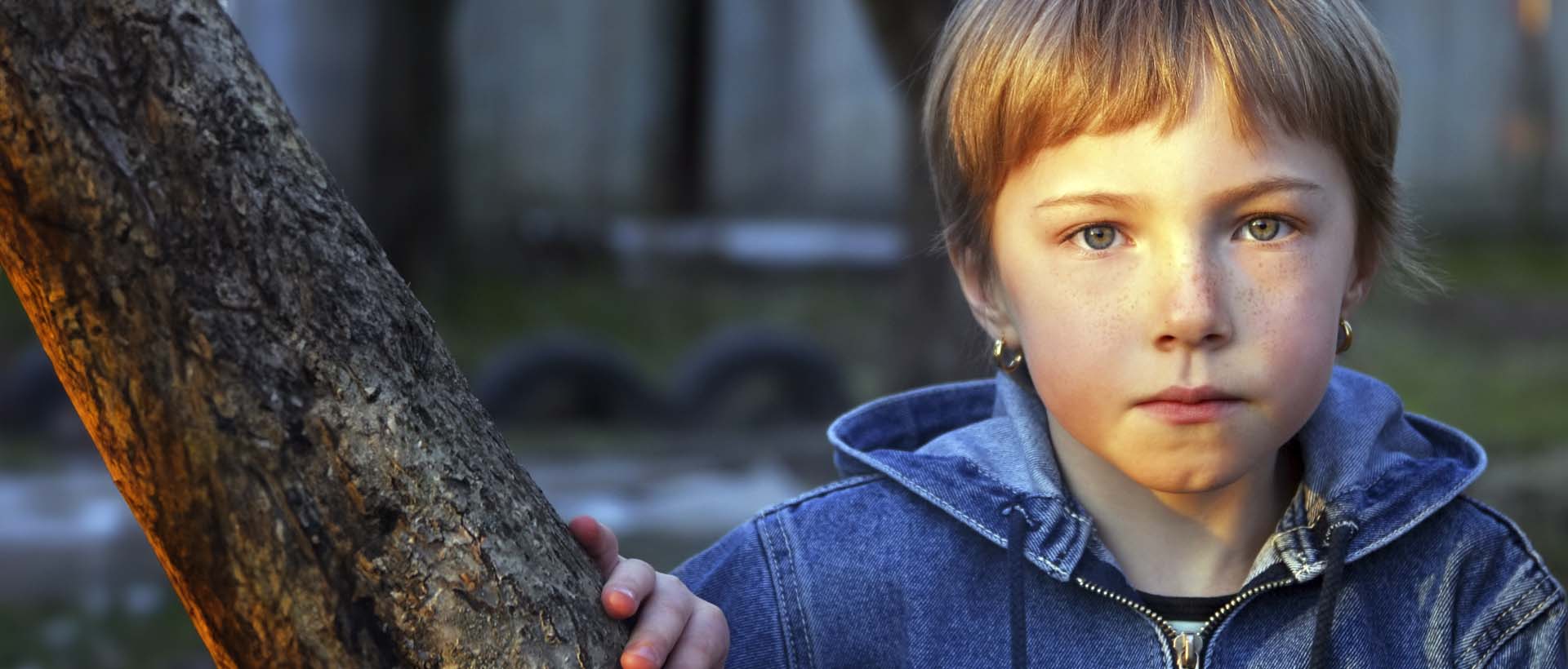 Ungt barn med alvorlig uttrykk i utendørs omgivelser, som symboliserer et barn som kan dra nytte av støtte fra PP-tjenesten. PP-tjenesten hjelper barn og unge med tilrettelegging i skole og barnehage, med saksbehandlingssystemer som støtter dette arbeidet.