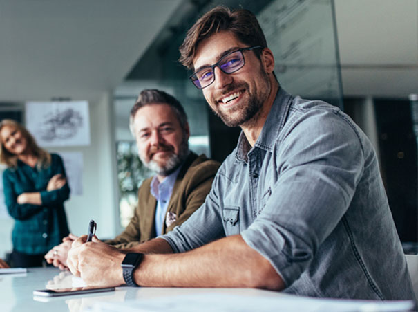 Smilende team av profesjonelle i et møte med Flyt, som diskuterer løsninger og samarbeid. En kompetansepartner i fokus, som hjelper bedrifter med å forbedre sine forretningsprosesser gjennom ekspertise og innovative løsninger.