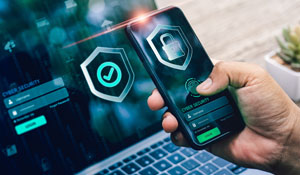 Smarttelefon med multifaktorautentisering vist foran bærbar PC. Beskytter persondata når datainnbrudd blir personlig for norske virksomheter. Som del av en sterk sikkerhetskultur med fokus på digital beskyttelse.