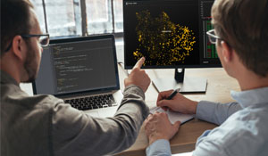 To IT-analytikere samarbeider om sikkerhetsledelse i sanntid ved å analysere datavisualisering og kode, som del av et proaktivt cybersikkerhetsmiljø.